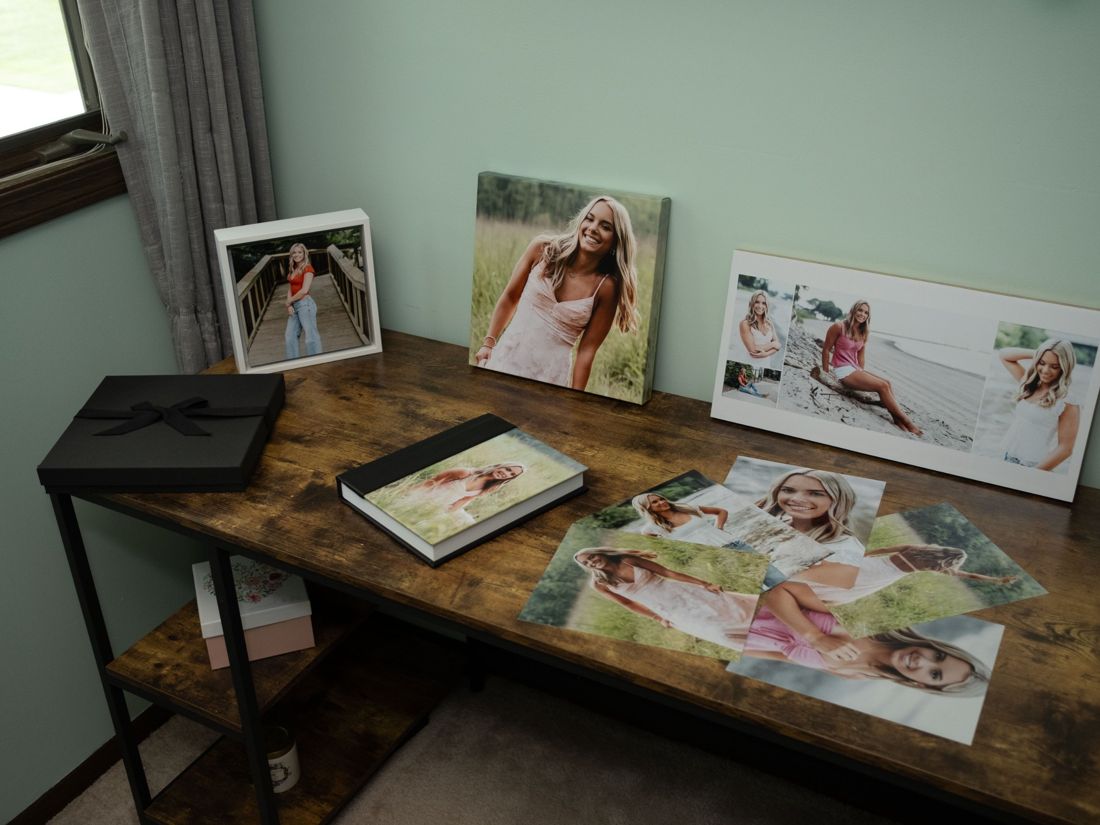 Gift prints, an album, a storyboard, a canvas and a float frame on a table